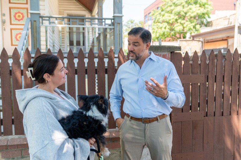 Daniel talking with a neighbor at her front fence