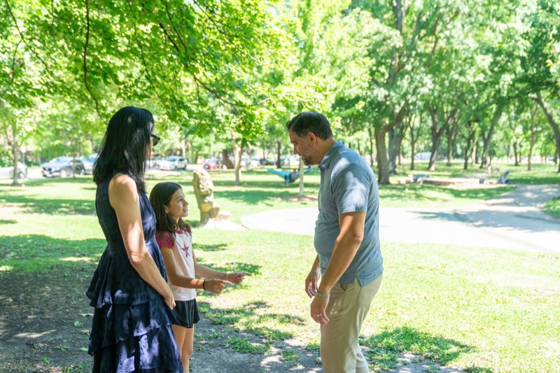 Daniel talking with a family in a Logan Square park