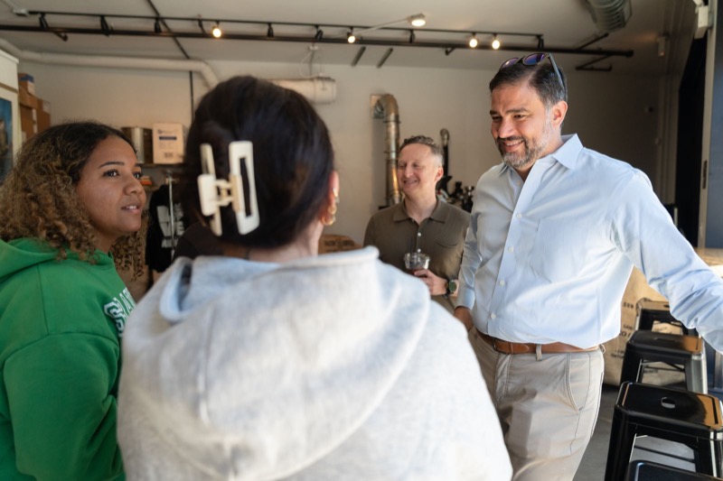 Daniel laughing with residents inside a neighborhood shop