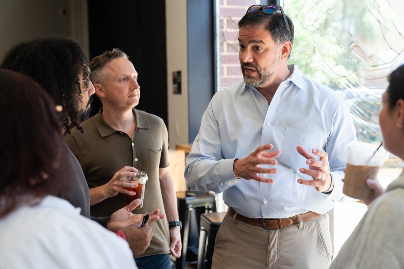 Daniel Tobón talking with a group of residents at a neighborhood coffee shop